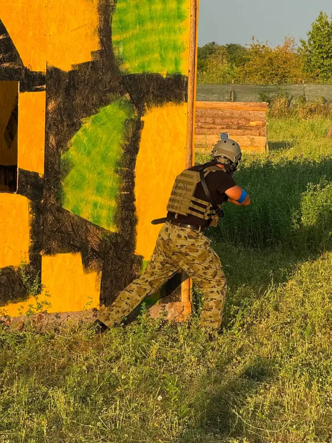 Jucător la colțul unei cabane pictate în galben, verde și negru
